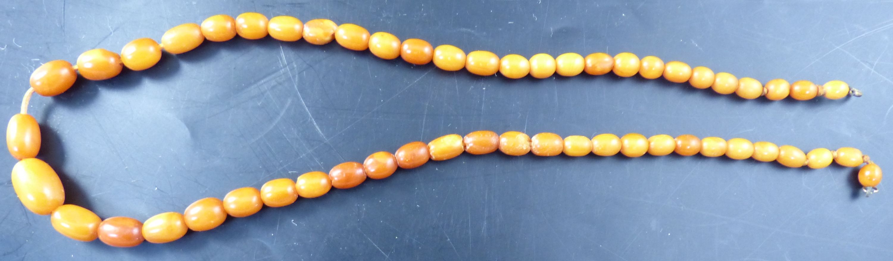 A collection of costume jewellery, principally necklaces, including an egg yolk amber bead necklace